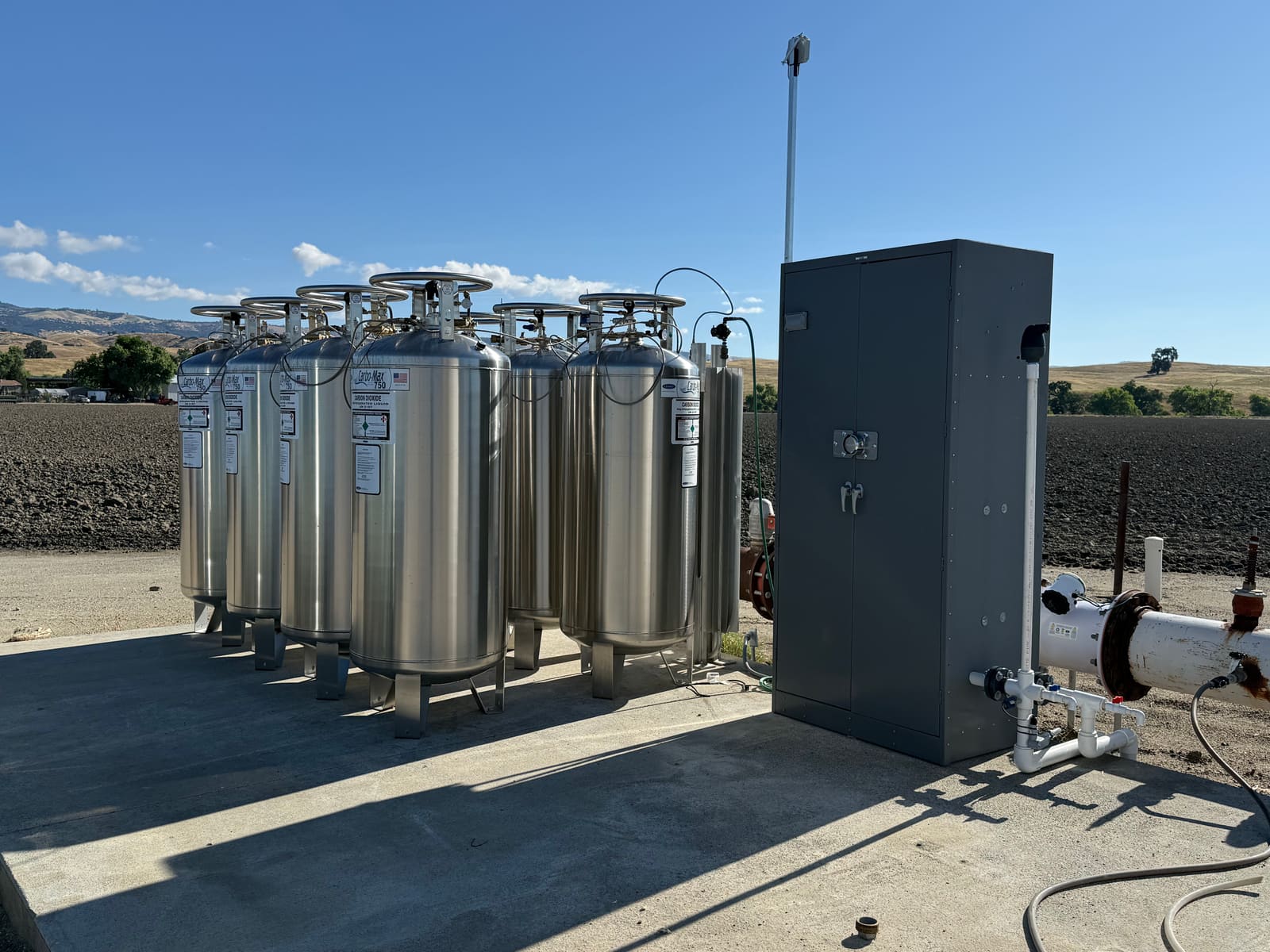 ECO2MIX CO₂ tanks and control cabinet installed beside a tilled field